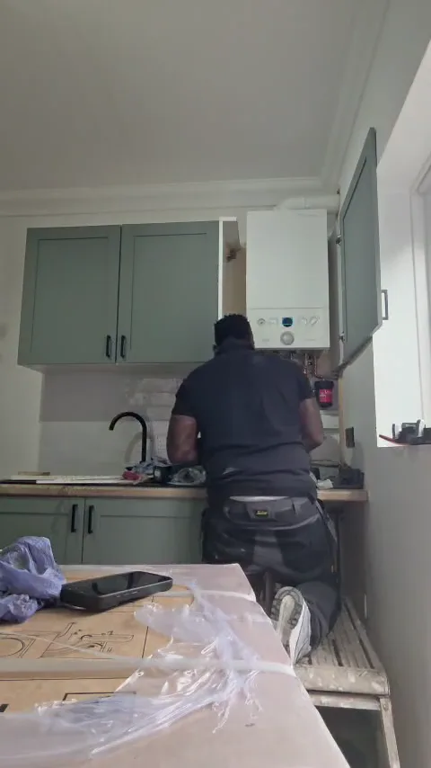 Engineer working on a kitchen boiler