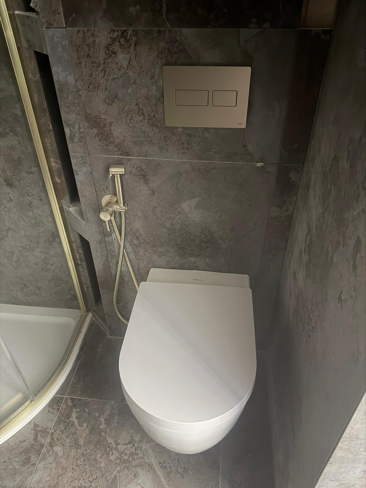 Wall-hung toilet with integrated bidet and floor-to-ceiling tiling