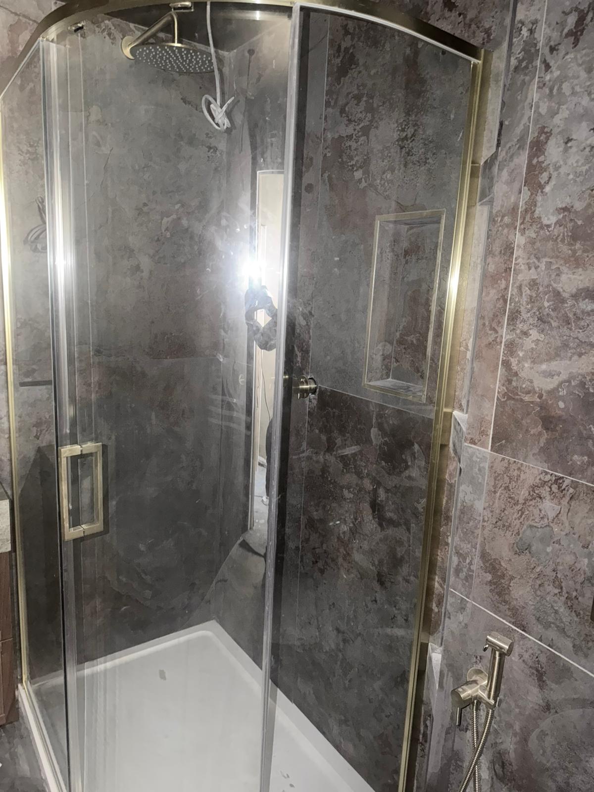 Walk-in shower enclosure with brass fittings and niche shelf